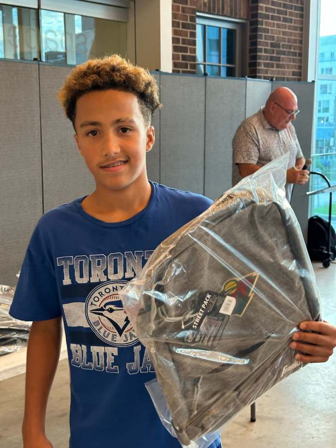 Jeune participant tenant un sac remis lors d’un événement communautaire.